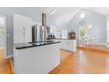 Bright kitchen featuring white cabinets, granite countertops, stainless steel appliances, and an adjoining dining area at 408 E Amelia Ave, Tampa, FL 33602
