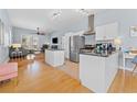 Open kitchen with white cabinets, stainless steel appliances, granite countertops, adjacent to a cozy living area at 408 E Amelia Ave, Tampa, FL 33602