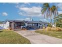 Mid-century modern home with updated facade, carport, and landscaped yard at 5201 40Th S St, St Petersburg, FL 33711