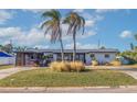 Mid-century modern home with updated facade, carport, and landscaped yard at 5201 40Th S St, St Petersburg, FL 33711