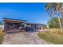 Mid-century modern home with updated facade, carport, and landscaped yard at 5201 40Th S St, St Petersburg, FL 33711