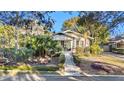 Front view of a renovated craftsman home with walkway and tropical landscaping at 5709 N Branch Ave, Tampa, FL 33604