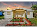 Beautiful single-story home featuring a covered porch and professionally landscaped front yard at dusk at 712 E Madison St, Plant City, FL 33563