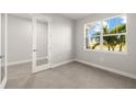 Bright bedroom featuring gray tile flooring, a large window with a view, and a glass door to another room at 11971 Starbright Path, Venice, FL 34293