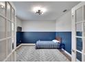 Small bedroom with blue wainscoting, a full-size bed, and French doors at 12783 Maple Bonsai Dr, Riverview, FL 33579