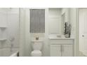 Clean bathroom with white vanity, tub shower combo, and gray accents at 13033 Garnet Raspberry Ave, Wimauma, FL 33598