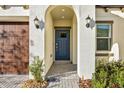 Front entry with blue door and arched entryway at 17523 Holly Well Ave, Wimauma, FL 33598