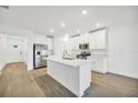 Modern kitchen with white cabinets, stainless steel appliances, and a large island at 17523 Holly Well Ave, Wimauma, FL 33598