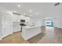 Open kitchen features stainless steel appliances and an island overlooking the living room at 17523 Holly Well Ave, Wimauma, FL 33598