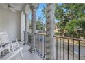 Relaxing balcony with white rocking chairs and a view of a tree-lined street at 2204 W Horatio St, Tampa, FL 33606