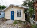 Light yellow house with blue door and small yard at 249 Boca Ciega Dr, Madeira Beach, FL 33708