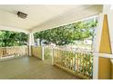 Spacious front porch with wooden railing and view of the street at 809 E Lambright St, Tampa, FL 33604