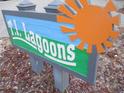 Neighborhood welcome sign featuring a sun and reads: T.L. Lagoons at 9901 1St E St # F, Treasure Island, FL 33706