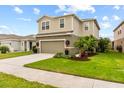 Two-story house with gray siding, two-car garage, and landscaped yard at 10675 Hawks Landing Dr, Land O Lakes, FL 34638