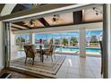 Outdoor patio with ceiling fans, dining table, and a view of the screened pool at 224 7Th E St, Tierra Verde, FL 33715