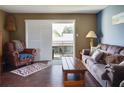 Living room with hardwood floors, comfy seating, and access to a private balcony at 4215 E Bay Dr # 1704C, Clearwater, FL 33764