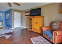 Bright living room with hardwood floors, large TV, and comfortable leather chair at 4215 E Bay Dr # 1704C, Clearwater, FL 33764