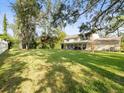Spacious backyard with lush green lawn, mature trees, and white fence at 10114 Lindelaan Dr, Tampa, FL 33618