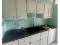 Clean kitchen with white cabinets, dark countertops, and modern sink at 1235 S Highland Ave # 2-206, Clearwater, FL 33756