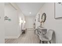 Bright and airy entryway with gray chairs and a bench at 30399 Marquette Ave, Wesley Chapel, FL 33545
