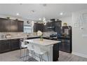 Modern kitchen featuring dark cabinets and a large island at 30399 Marquette Ave, Wesley Chapel, FL 33545
