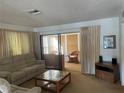 Cozy living room with sliding glass doors leading to a sunroom or enclosed patio at 2165 Corbin Pl # A, Palm Harbor, FL 34683