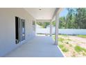 Covered patio features sliding glass doors, white columns, and views of the backyard at 413 Shannon Estates Ct, Plant City, FL 33563