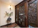 Intricate carved wood front door and entry with a tiled floor at 6500 Sunset Way # 418, St Pete Beach, FL 33706