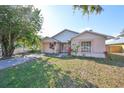 One-story home showcasing a peach-colored exterior and a neat front yard at 11 Leaning Palm Ct, Plant City, FL 33563
