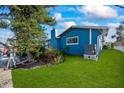 Side view of blue house, showing landscaping and AC unit at 1409 Ne 49Th Ne Ave, St Petersburg, FL 33703