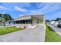 Single-wide manufactured home with covered porch and landscaped yard at 4961 Britni Way, Zephyrhills, FL 33541