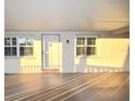 Exterior elevation of a home with covered walkway, front door, and windows with shutters at sunset at 920 Virginia St # 204, Dunedin, FL 34698