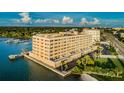 Aerial exterior of complex by the water, with docks, trees, and beautiful sky at 100 Bluff View Dr # 207C, Belleair Bluffs, FL 33770