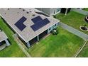 Aerial view of the backyard with solar panels, a screened lanai, and a well-maintained lawn at 10058 Shoreline View Way, Wesley Chapel, FL 33545