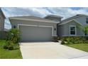 Beautiful home featuring an attached two-car garage, well-kept lawn, and attractive landscaping at 10058 Shoreline View Way, Wesley Chapel, FL 33545