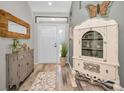 Bright entryway with hardwood floors, antique cabinet, and wood mirror at 1012 Osprey Ct, Tarpon Springs, FL 34689