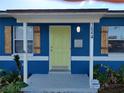Light-yellow front door with blue house exterior and wooden shutters at 1644 24Th N Ave, St Petersburg, FL 33713