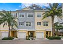 Three-story townhouses with attached garages, featuring a mix of gray and yellow siding at 3192 Nautical S Pl, St Petersburg, FL 33712