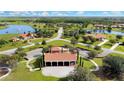 An aerial view of a community with homes surrounding a pond and green spaces at 5317 Lake Venice Dr, Wimauma, FL 33598