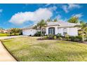 Single-Gathering home with a white exterior, lush landscaping, and a two-car garage at 728 Thistlelake Dr, Venice, FL 34293