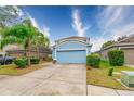 Two-story light blue house with a two-car garage and manicured lawn at 10521 Summer Azure Dr, Riverview, FL 33578