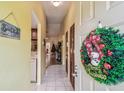 View of the foyer with a Christmas wreath on the door and a glimpse of the living room and kitchen at 11511 113Th St # 27C, Largo, FL 33778