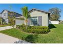 Lovely home featuring a well-manicured front yard with decorative bushes and a palm tree at 13388 Great Plains Dr, Riverview, FL 33579