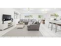 Bright, open-concept living area with a large sectional sofa, stylish decor, and abundant natural light at 13388 Great Plains Dr, Riverview, FL 33579