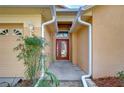 Inviting front entrance with a red door, neutral stucco exterior, and lovely landscaping at 2529 Clareside Dr, Valrico, FL 33596