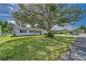 White single story home with lush green lawn and large tree at 39093 Citadel Cir, Zephyrhills, FL 33542