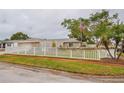House exterior showcasing a large yard with a white picket fence at 6321 Staunton Dr, Holiday, FL 34690