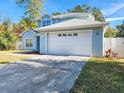 A light blue two-story house with a white garage door, and driveway at 7115 W Creek Dr, Tampa, FL 33615