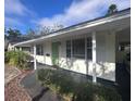 House exterior showcasing a classic design, green door, and neat landscaping at 8153 22Nd N Ave, St Petersburg, FL 33710