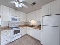 Bright white kitchen featuring white appliances, cabinets, and a tile backsplash at 8153 22Nd N Ave, St Petersburg, FL 33710